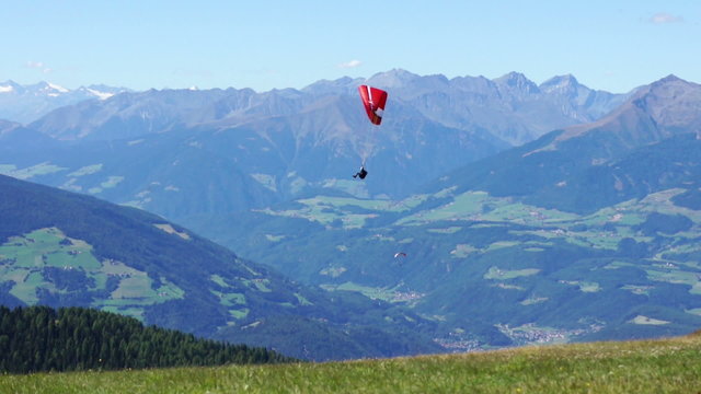 Paragliding over the mountains against clear blue sky, Italy