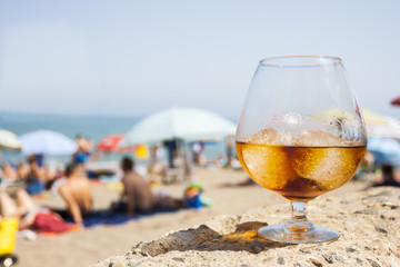 glass with drink on the beach in summer
