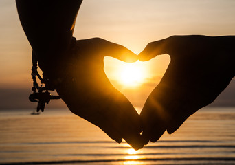 Hand make heart and sun set
