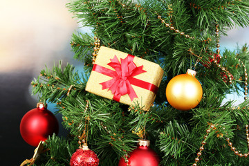 Gift on Christmas tree on room background