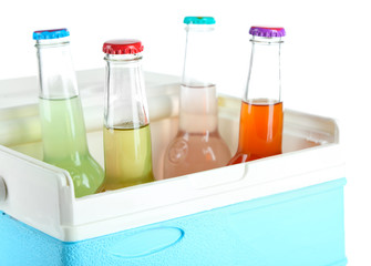 Drinks in glass bottles in mini fridge isolated on white