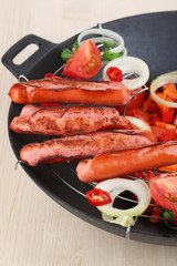 Delicious sausages with vegetables in wok