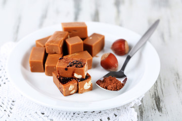 Many toffee on plate on napkin on wooden table