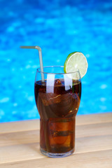 Tasty cocktail on swimming pool background