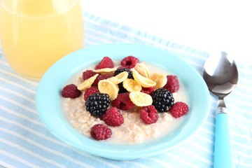 Oatmeal in bowl with berries isolated on white