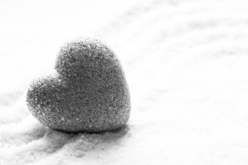 Grey zen stone in shape of heart, on sand background