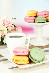 Coffee and macaroons on table on light background