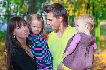 Fototapeta premium Portrait of Young charming family with two kida enjoying the