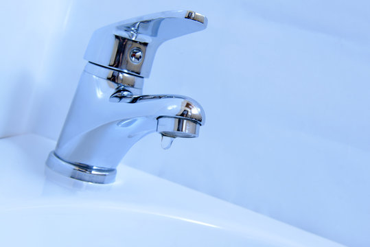 Close-up of human hands being washed under faucet in bathroom,