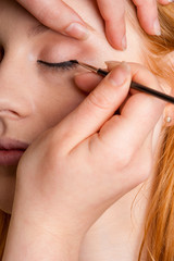 Professional makeup artist artist applies eyeliner