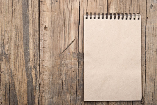 brown blank note book on grunge wood