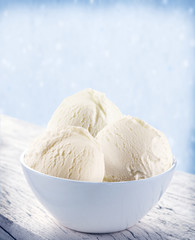Vanilla ice-cream scoops in white cup.