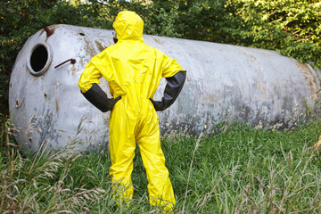 technician in uniform examining large stainless tank