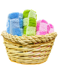Obraz premium Rolls of different colors of towels in a wicker basket.
