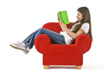 Mädchen ließt ein Buch im roten Sessel