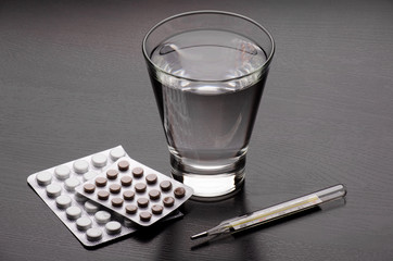Water glass and medicaments on table