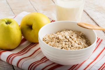 Oat flakes in bowl with apple and milk
