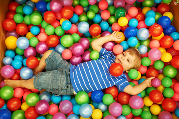 Fototapeta na wymiar Happy child playing with colorful plastic balls