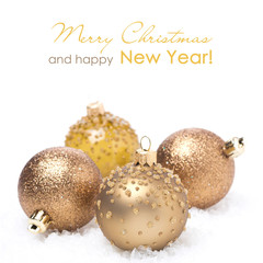 Different golden Christmas balls in the snow, isolated