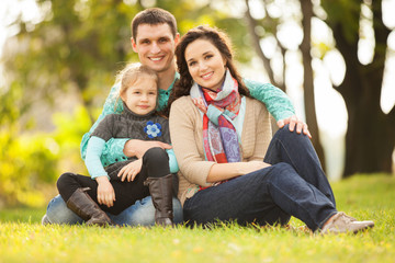 Fototapeta premium Happy mother, father and daughter in the park