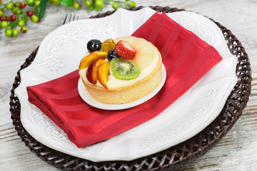 Fruit tart pies with forks on white plate, close up