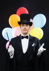 magician in top hat with magic wand showing trick