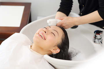 Fototapeta na wymiar シャンプー台で髪を洗う女性