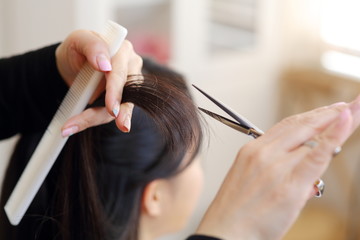 女性の毛先を切る