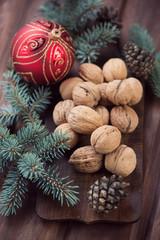 Walnuts, fir-tree branches and cones, xmas ball, vertical shot