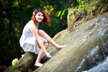 Naklejka na ściany i meble Young asian woman enjoying the pure waters of a mountain river i