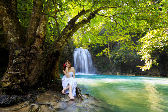Young woman relaxing in water stream near waterfall - Powered by Adobe