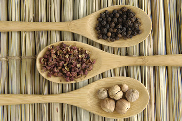 Allspice, peppercorns , nutmeg seeds on wooden spoon