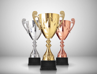 golden,silver and bronze trophies on gray background