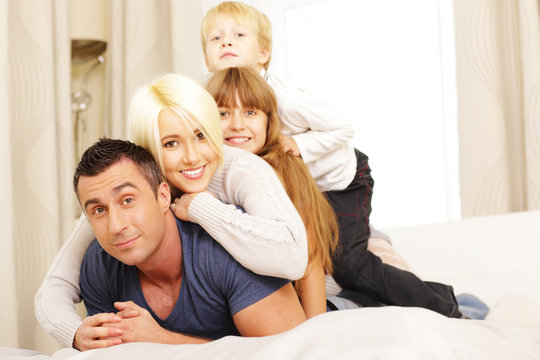 Family lying on the bed at home