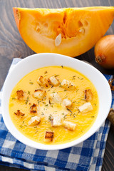 Pumpkin soup in white bowl