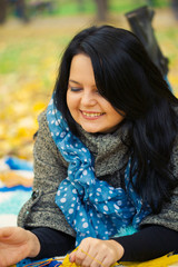 Naklejka premium Young woman laying in autumn leaves