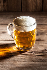 Mug of beer on wooden background