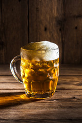 Mug of beer on wooden background