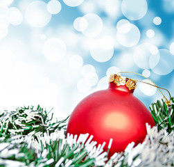Red christmas ornament ball against blue bokeh background