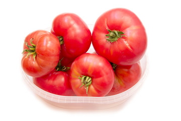 Organic red tomatoes in a plastic container