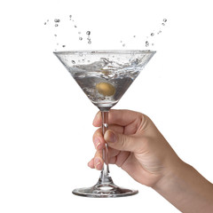 Martini with splash and olive in womans hand isolated on white