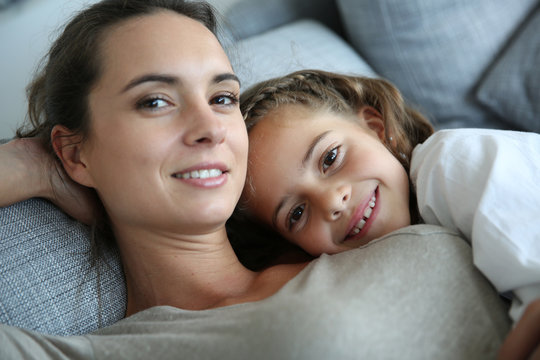 Mom and little girl relaxing in sofa
