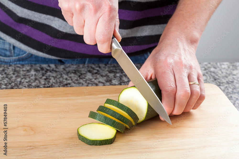 Wall mural man cutting a zucchini