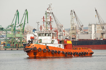 Fototapeta premium Red tug boat in the port