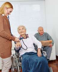 Pflegedienst misst Blutdruck bei Seniorin
