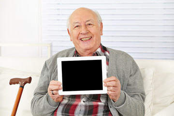 Senior hält Tablet Computer hoch