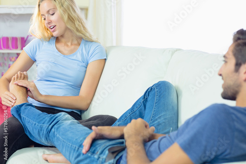 Cute Young Woman Massaging The Feet Of Her Boyfriend Stock Photo And