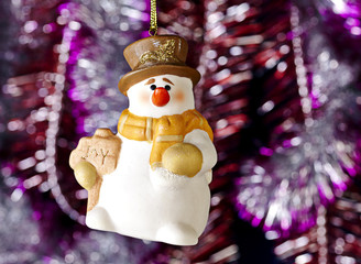 Happy Christmas snowman, tinsel as background. Selective focus