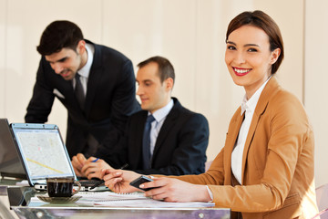 business woman smiling with colleagues in background