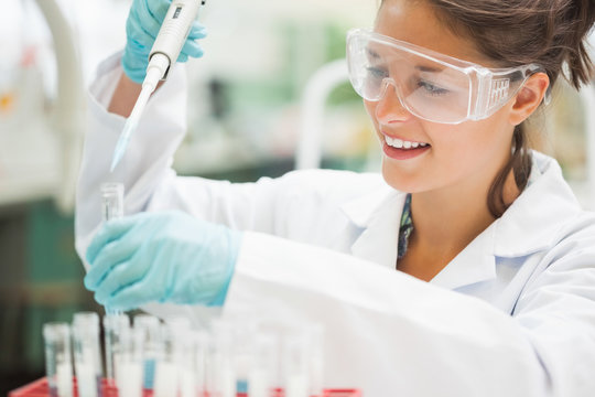 Attractive smiling student holding big pipette